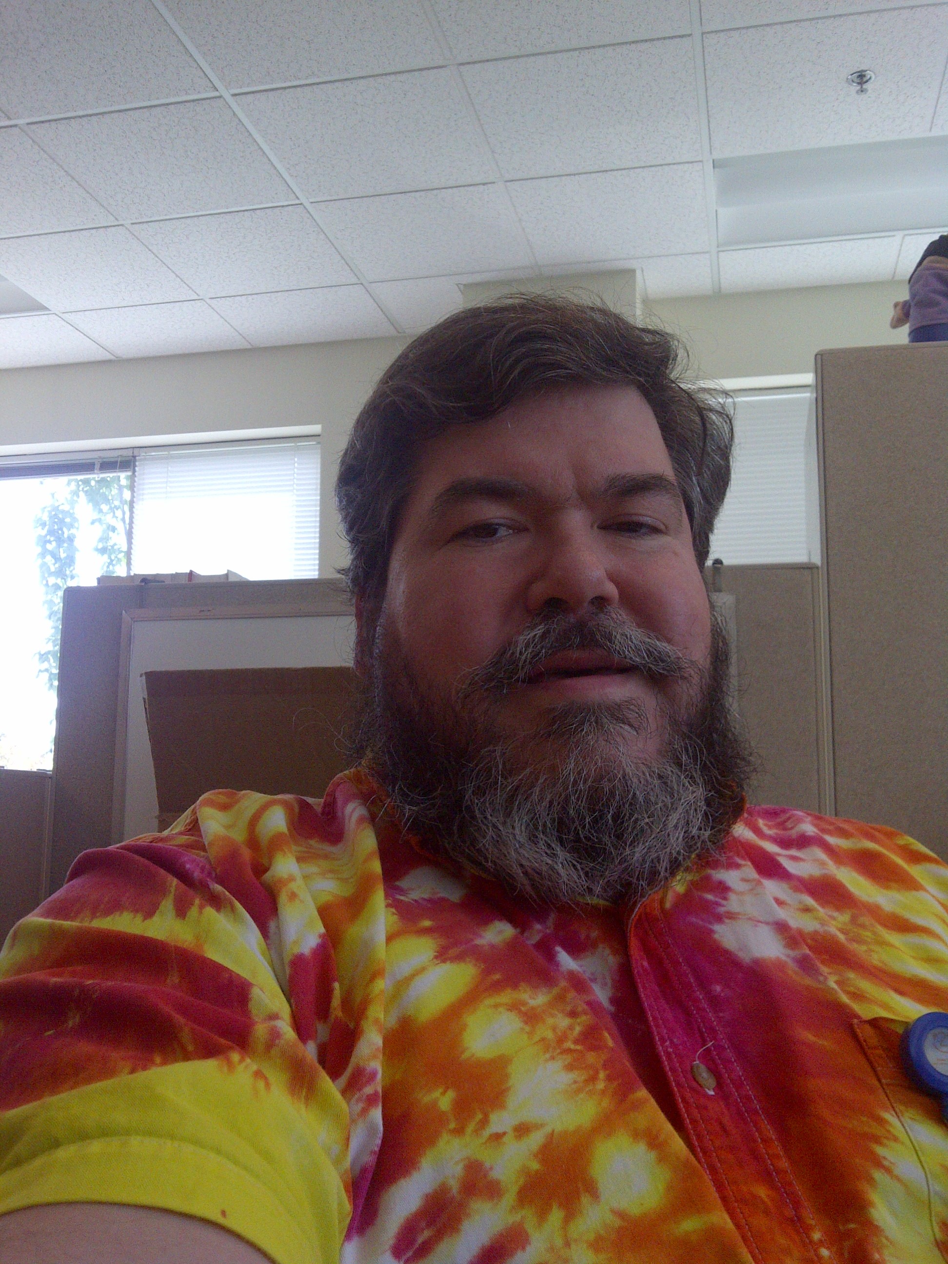 bigmacbear in his office, Bothell, WA, in a red and yellow tie-dye dress shirt 
