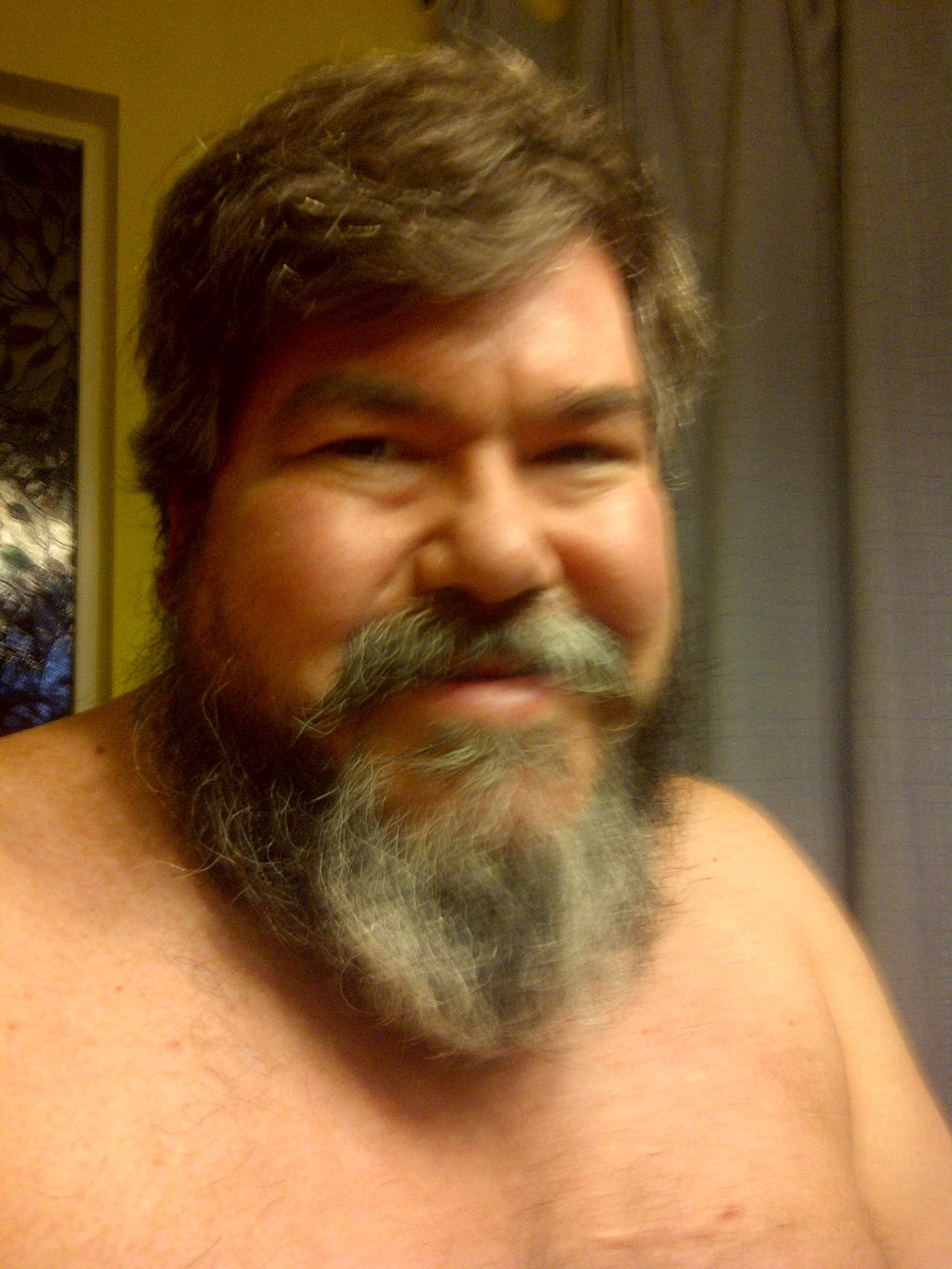 bigmacbear standing shirtless in the dining room.