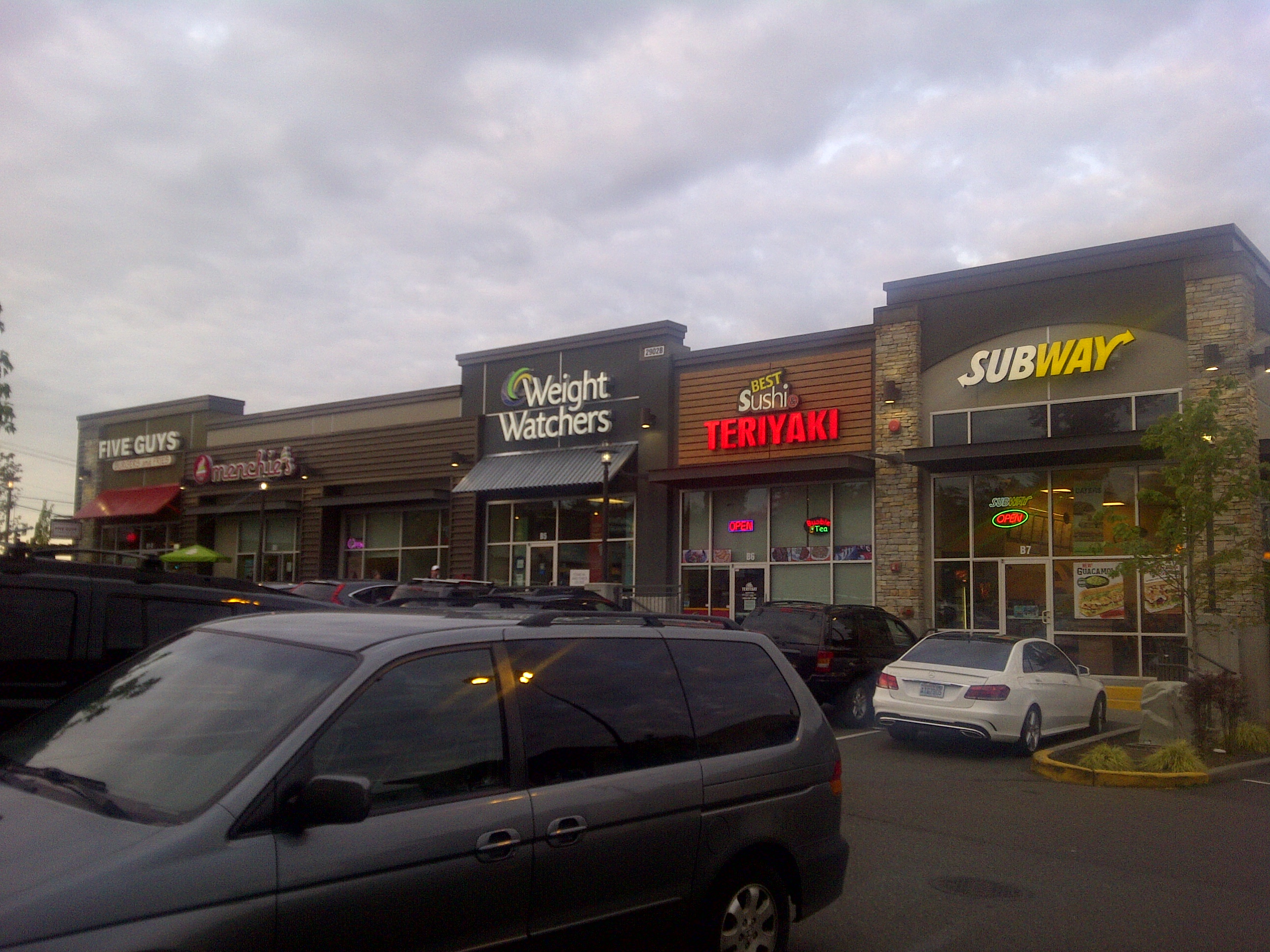 A grouping of five storefronts, L to R: Five Guys, Menchies, Weight Watchers, Best Sushi Teriyaki, Subway.